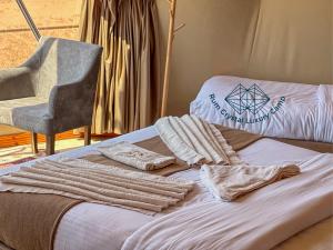瓦迪拉姆Rum Crystal Luxury Camp的客房内的一张带毛巾和椅子的床