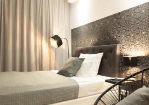 美因河畔法兰克福帕拉贡公寓式酒店的一间卧室配有一张床和一张带台灯的桌子