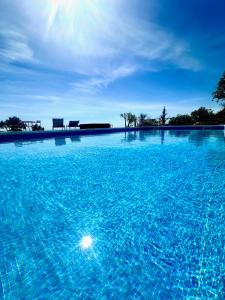 埃斯托伊Fantastic villa with panoramic coastal & sea views的大型蓝色游泳池,配有两把椅子
