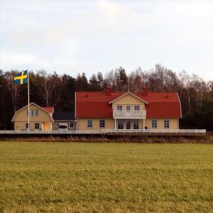 哥德堡Gula huset的田间中带旗帜的房子