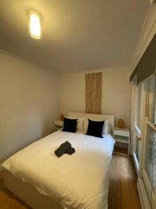 悉尼3 Bedroom House Ideal for Family - Ultimo的卧室配有一张带黑色枕头的大型白色床。