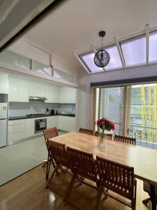 悉尼3 Bedroom House Ideal for Family - Ultimo的厨房以及带木桌和椅子的用餐室。