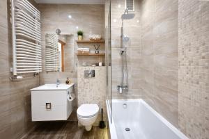 克拉科夫MalinoweLove - 3 pokoje, parking, ogród的浴室配有卫生间、浴缸和水槽。