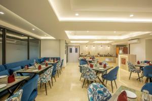 古尔冈OPO Hotel Iffco Chowk的一间设有蓝色桌椅的餐厅和一间自助餐厅