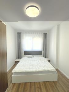 乌罗舍瓦茨City Center 1bedroom的白色卧室设有一张大床和窗户