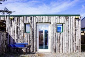 瓦伦西亚岛Retro Caravans at Valentia Island Escape的木结构建筑,设有门和蓝色长凳