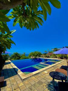 艾湄湾巴厘岛布瓦纳别墅的一个带椅子和遮阳伞的游泳池