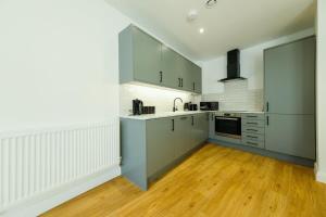 布里斯托Hotwells apartments flat 6- Hopewell的厨房铺有木地板,配有灰色橱柜。