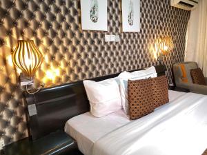 阿布贾Newland Luxury Hotels and Apartments的酒店客房,配有一张带床头板的床