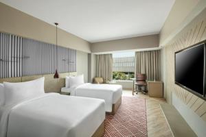 古尔冈古尔冈29区丽怡酒店及套房的酒店客房设有两张床和一台平面电视。