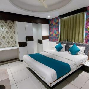 艾哈迈达巴德Hotel Sigma的一间卧室配有一张带蓝色枕头的大床