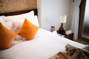 美奈克里夫公寓的一间卧室配有带白色床单和橙色枕头的床。