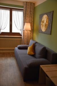 格拉本斯塔特Pension Langerspacher的带沙发和窗户的客厅