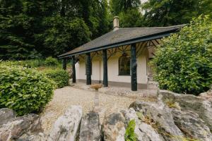 布里斯托The Lodge Gatehouse at Coombe Lodge的一座小建筑,花园中设有一个鸟浴池