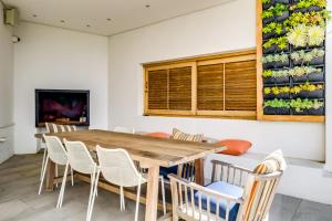 开普敦Oranjezicht Heritage Home的一间带木桌和椅子的用餐室