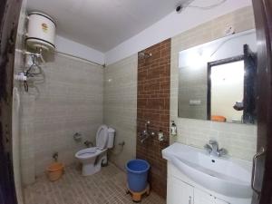 奈尼塔尔Hotel Cottage Orchid Nainital - Parking Facilities - Luxury & Hygiene Room - Best Seller的一间带卫生间、水槽和镜子的浴室