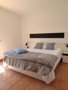 MajanichoVilla Punta Calma的卧室配有带蓝色枕头的大型白色床