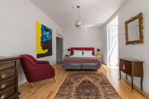 里斯本希尔都特索大巴萨旅馆的一间卧室配有一张床和一张红色椅子
