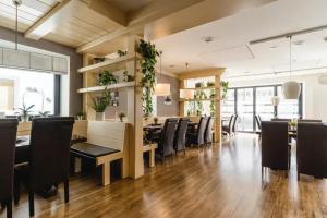 埃伯曼施塔特松内29酒店的用餐室配有黑色桌椅和植物
