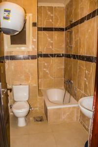 艾因苏赫纳LASIRENA MANI EGYPT-Family Only的浴室配有卫生间、浴缸和水槽。