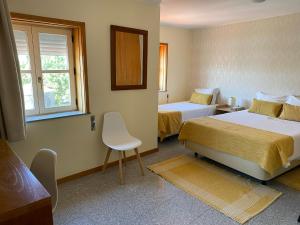 维亚纳堡Enjoy Viana - Guest House的酒店客房设有两张床和窗户。