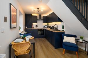 卡迪夫Gad Suite by Koya Homes - Cardiff City Centre Location!! 2 En-suites的厨房配有蓝色橱柜和桌椅