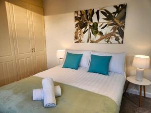 格洛斯特Gilpin villa 4Bedroom WiFi, Parking, Netflix, Garden的一间卧室配有一张带蓝色枕头的大床