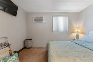 北怀尔德伍德422 E 4th Ave, Unit 206的一间卧室设有一张床、一个窗口和一台电视