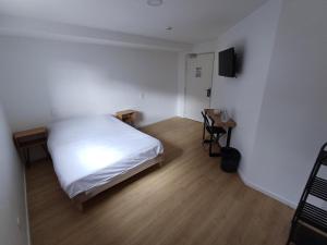克莱苏伊CRYSTAL HOTEL的一间小卧室,配有白色的床和电视