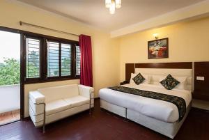 奈尼塔尔Hotel Cottage Orchid Nainital - Parking Facilities - Luxury & Hygiene Room - Best Seller的一间卧室配有一张床、一把椅子和窗户。