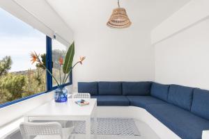 苏尼翁Renovated Seaside Cabin in Sounio的客厅配有蓝色的沙发和桌子