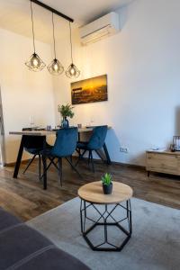 威斯巴登BeMyGuest - 3 Zimmer Maisonette - Zentral - Klimaanlage - Aufzug的一间带桌子和蓝色椅子的用餐室