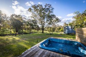 WindeyerTiny House Farmstay at Dreams Alpaca Farm - A Windeyer Outback Experience的庭院旁甲板上的热水浴池