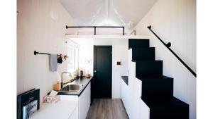 KorweingubooraThe Perch的一个小房子里一个小厨房,有黑色的楼梯