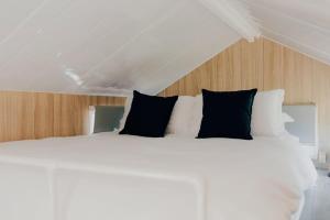亚勒旺加The Murray Grange的一张白色的床,上面有黑色枕头