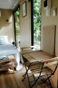 PalmwoodsCockatoo Cabin的一间卧室配有一张床、一张桌子和一个窗户。
