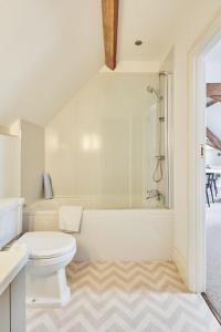 HolmesfieldHidden Hayloft的白色的浴室设有卫生间和浴缸。