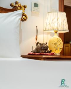 河内Paradise Suites Trich Sai的床头桌子上的一盏灯