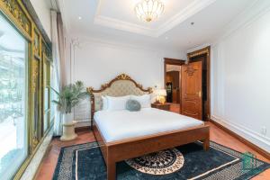 河内Paradise Suites Trich Sai的一间卧室配有一张带白色床单和地毯的床。
