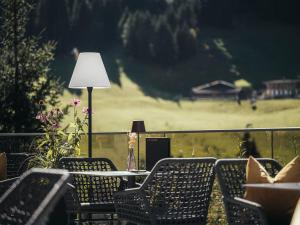 希帕赫Hotel Bergkristall Zillertal的阳台配有桌椅和台灯