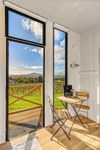 亚拉腊Montara Views 1的客房设有桌椅和大窗户。