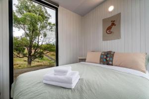 MacclesfieldThe Meadows Tiny House的一间卧室设有一张大床和大窗户