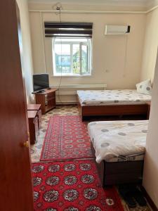 努库斯Guest House Medic的一间设有两张床和红地毯的客房