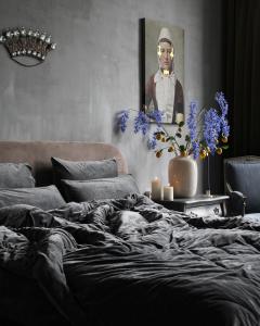 米德尔堡Logies aan de Dam的卧室配有一张床和一张男子肖像