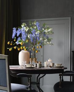 米德尔堡Logies aan de Dam的一张桌子,上面有花瓶,上面有蓝色的花
