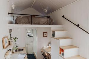 Ringtail CreekNoosa Tiny Home的小房间设有高架床和书桌