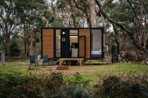 Dadswells BridgeNorthern Grampians Getaway by Tiny Away的田野里的一个小房子,配有桌椅