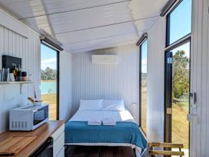 ToogoomTurtle Island Lakeside Tiny House的一间位于小房子的卧室,配有床和窗户