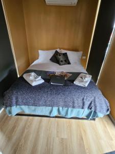 WillungaAlma's Tiny House的一张带两个枕头的床和一本书