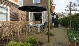 Wolphaartsdijkootmen的一个带桌子和遮阳伞的庭院